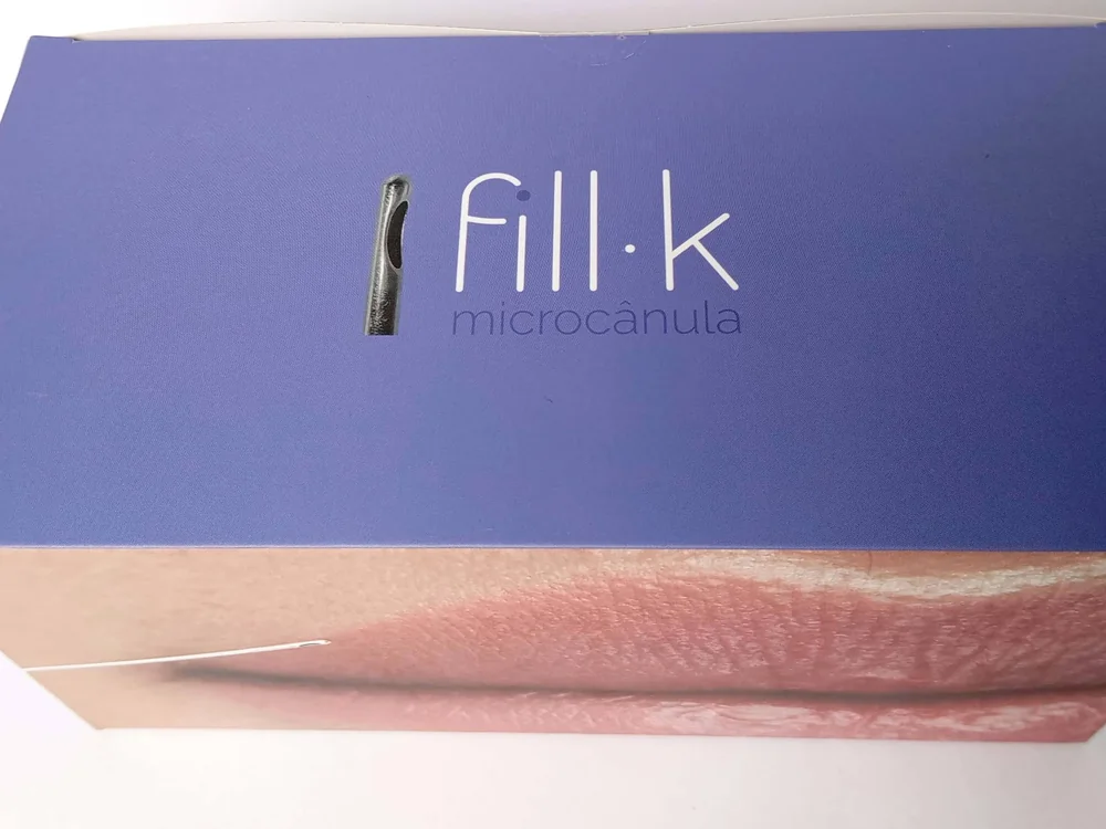 Caixa fechada da microcânula fill·k, com o logotipo e a imagem de contorno labial impressos